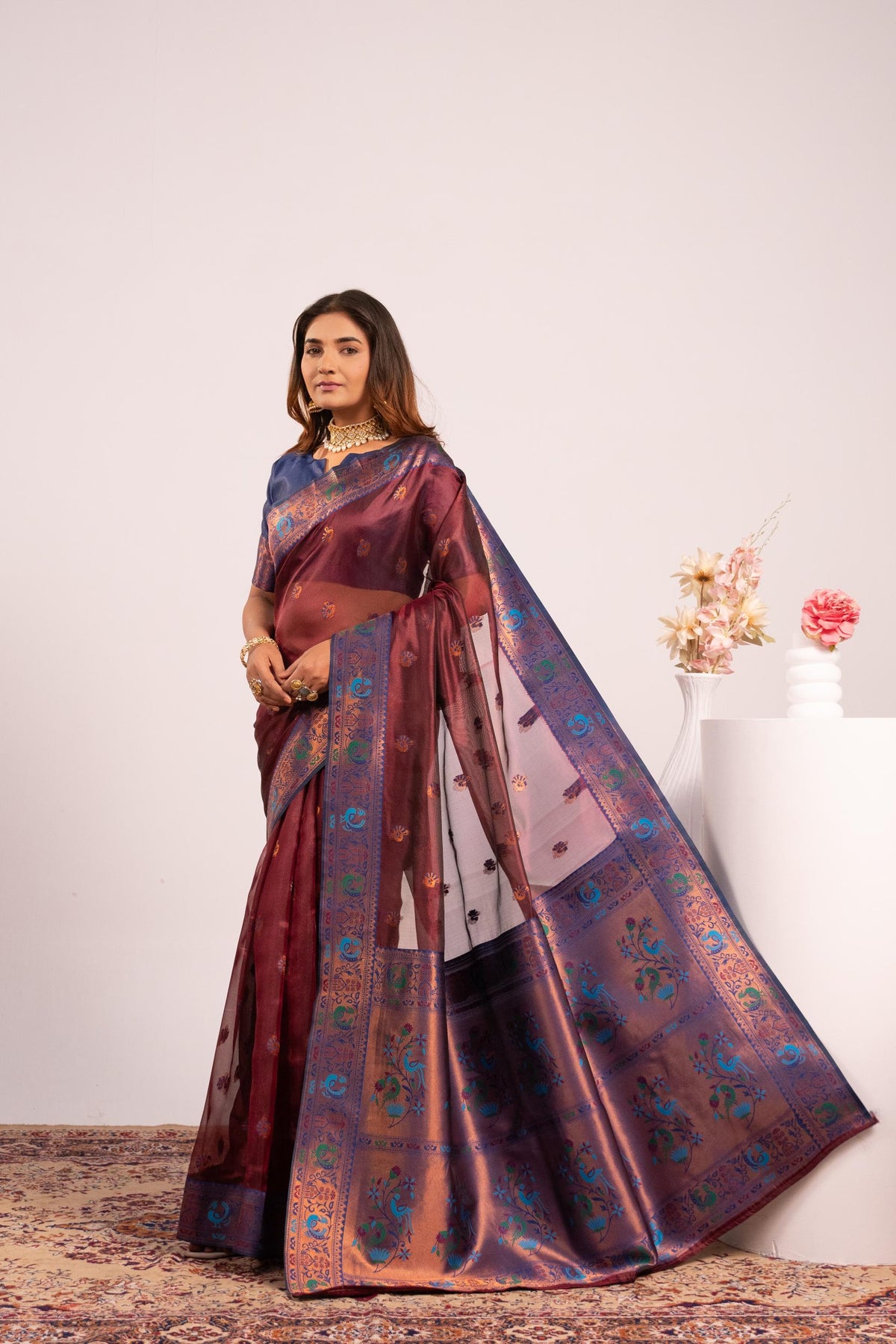 A beautiful coffee-colored soft tissue silk saree with intricate gold zari woven details and a matching blouse piece.