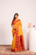 Woman wearing a vibrant yellow soft tissue silk saree with zari weaving and matching blouse