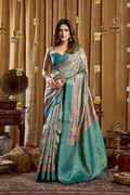 Turquoise Banarasi saree with digital cluster print and tassels, includes matching blouse