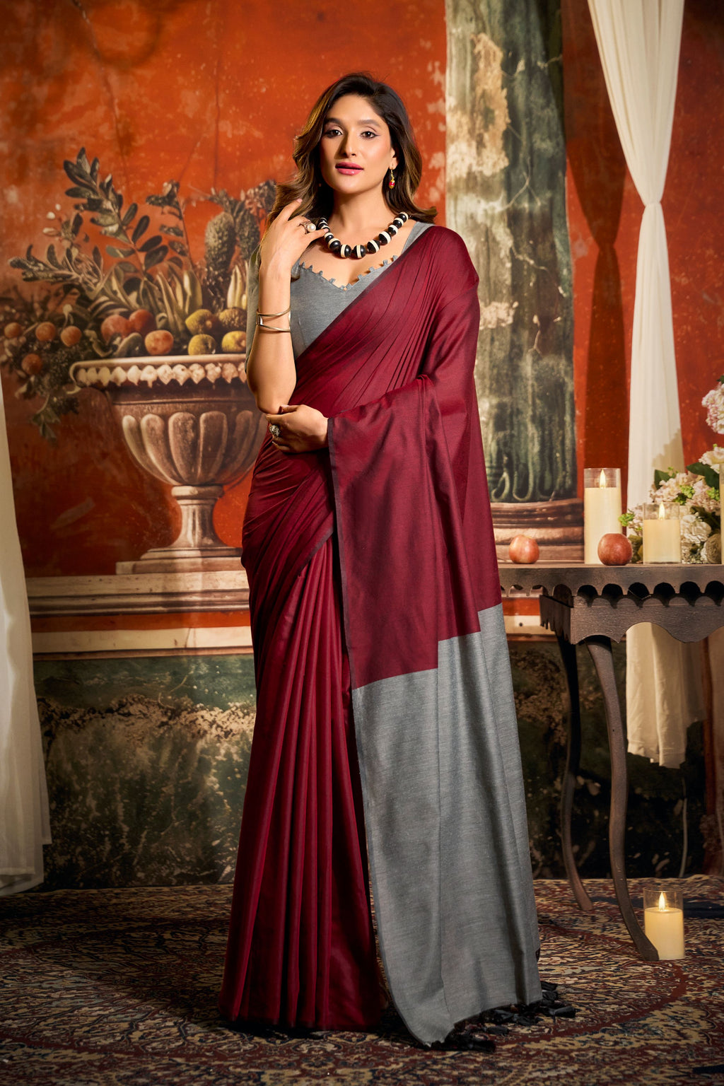 Maroon cotton saree with a contrast pallu and decorative tassels