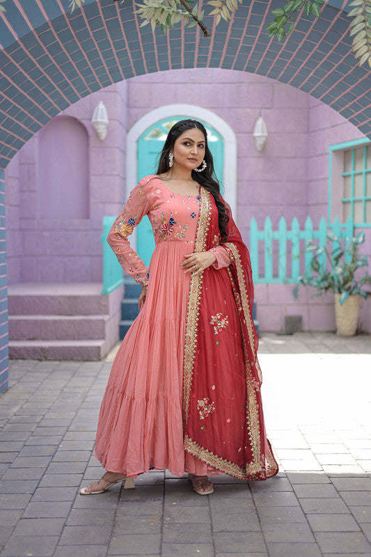 Peach colored faux georgette Anarkali dress with detailed thread embroidery and matching dupatta.