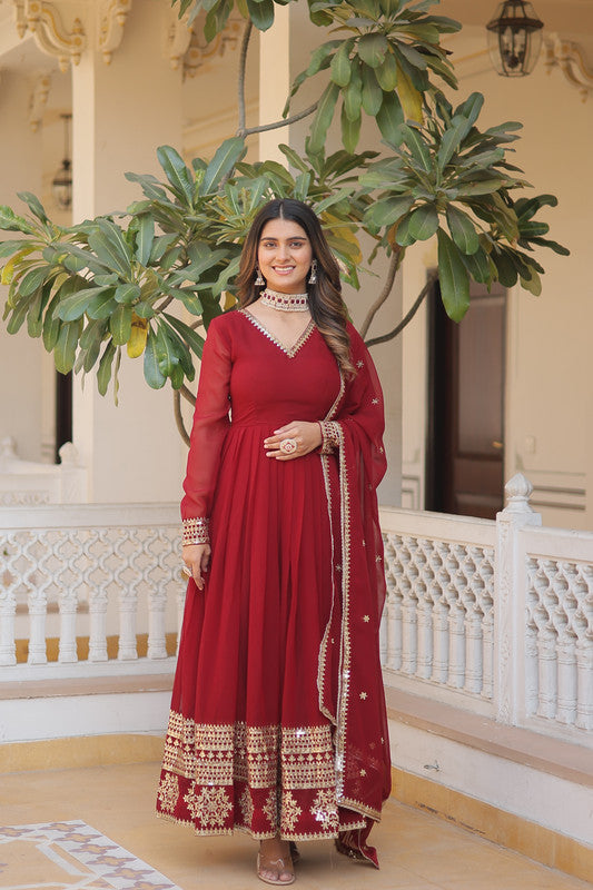 Woman wearing a maroon faux blooming Anarkali dress with intricate sequins embroidery and a matching dupatta.