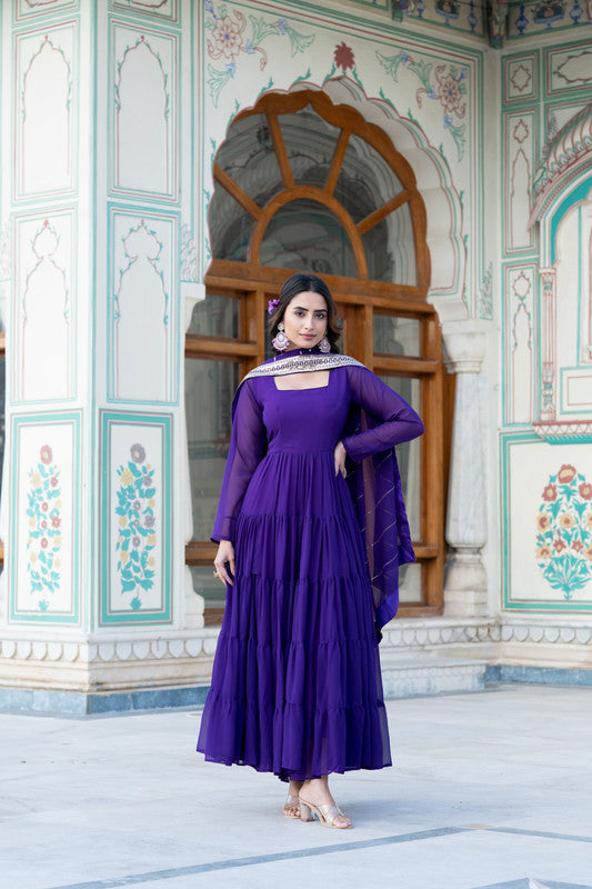 Woman wearing a floor-length purple faux georgette Anarkali dress with frill work and dupatta.