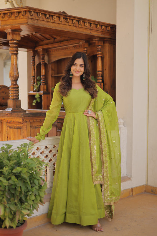 Green Russian silk Anarkali dress with gold detailing and flared kali pattern, paired with a matching dupatta.