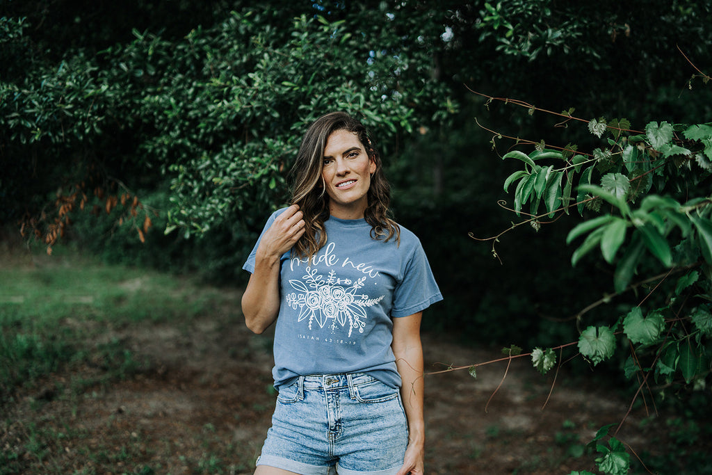 Woman wearing a blue and white Made New faith-based cotton graphic tee