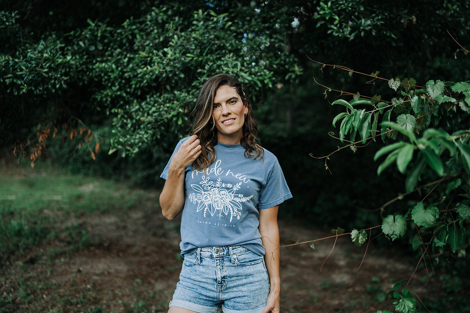 Woman wearing a blue and white Made New faith-based cotton graphic tee
