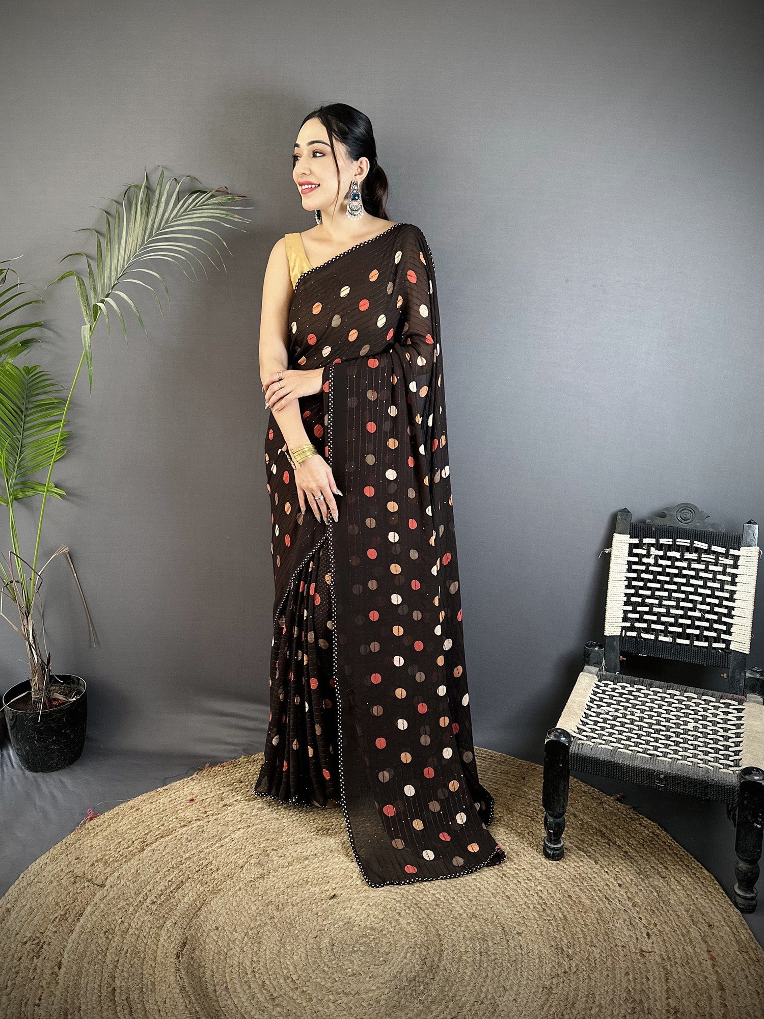 Black georgette saree with white polka dot pattern and matching blouse.