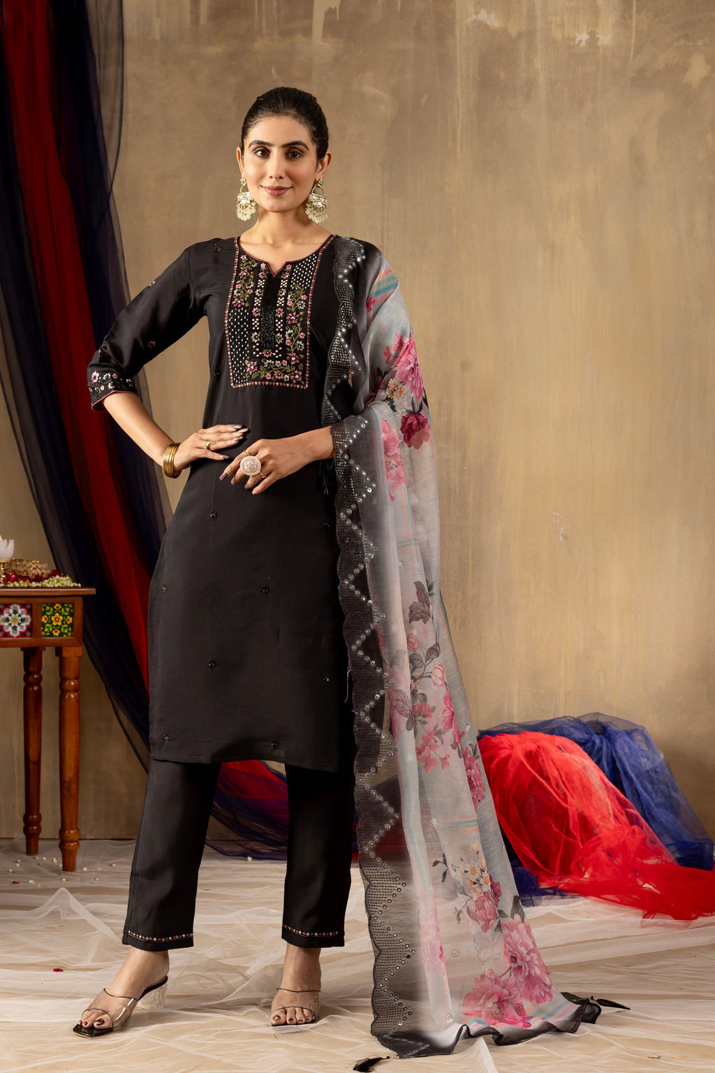 A sophisticated black Roman Silk kurta set featuring intricate hand-embroidered floral patterns and sequin embellishments with matching pants.