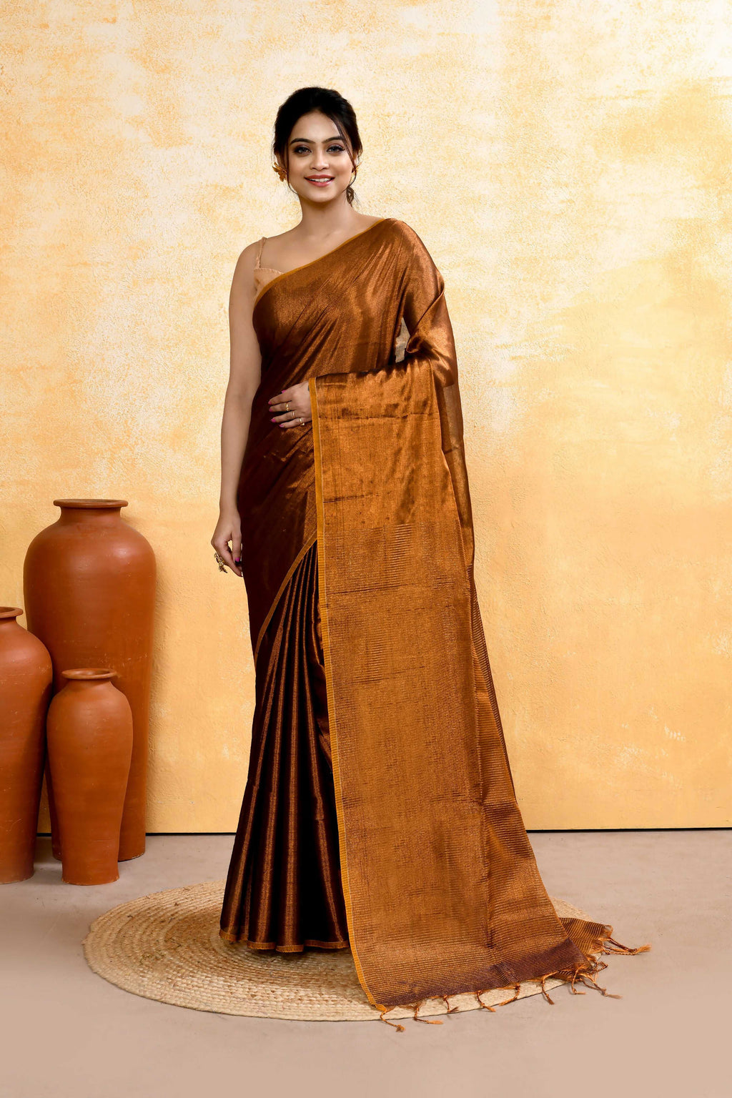 Woman wearing a Copper Dual Tone Organic Tissue Saree with a matching blouse piece