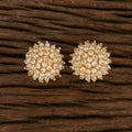 A pair of traditional golden white Kundan and pearl drop earrings displayed against a neutral background.