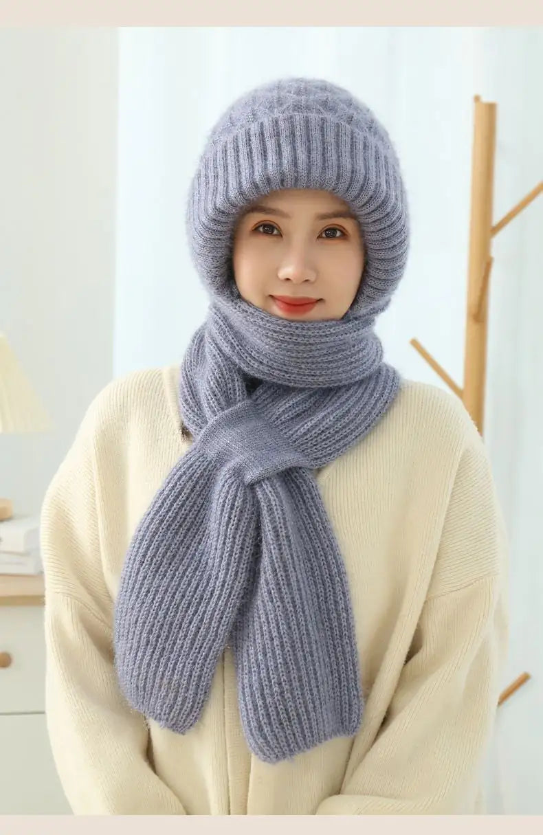A woman wearing a matching fleece-lined knitted hat and scarf set in grey and pink options