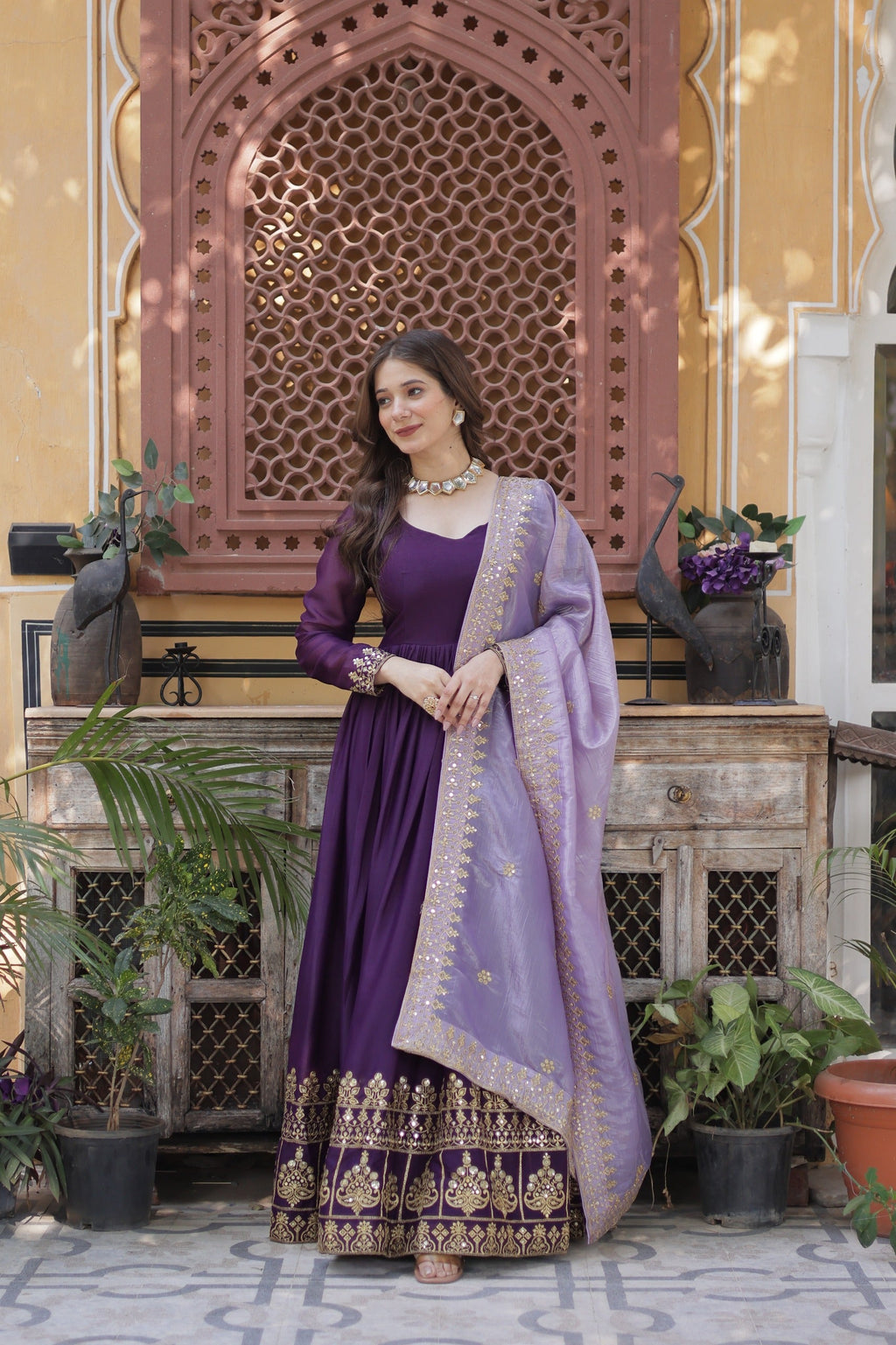 A beautiful floor-length violet georgette gown with gold embroidery, sequins, and a lavender dupatta.