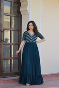 Woman wearing a Rama color georgette gown with intricate multithreaded beadwork and embroidery.