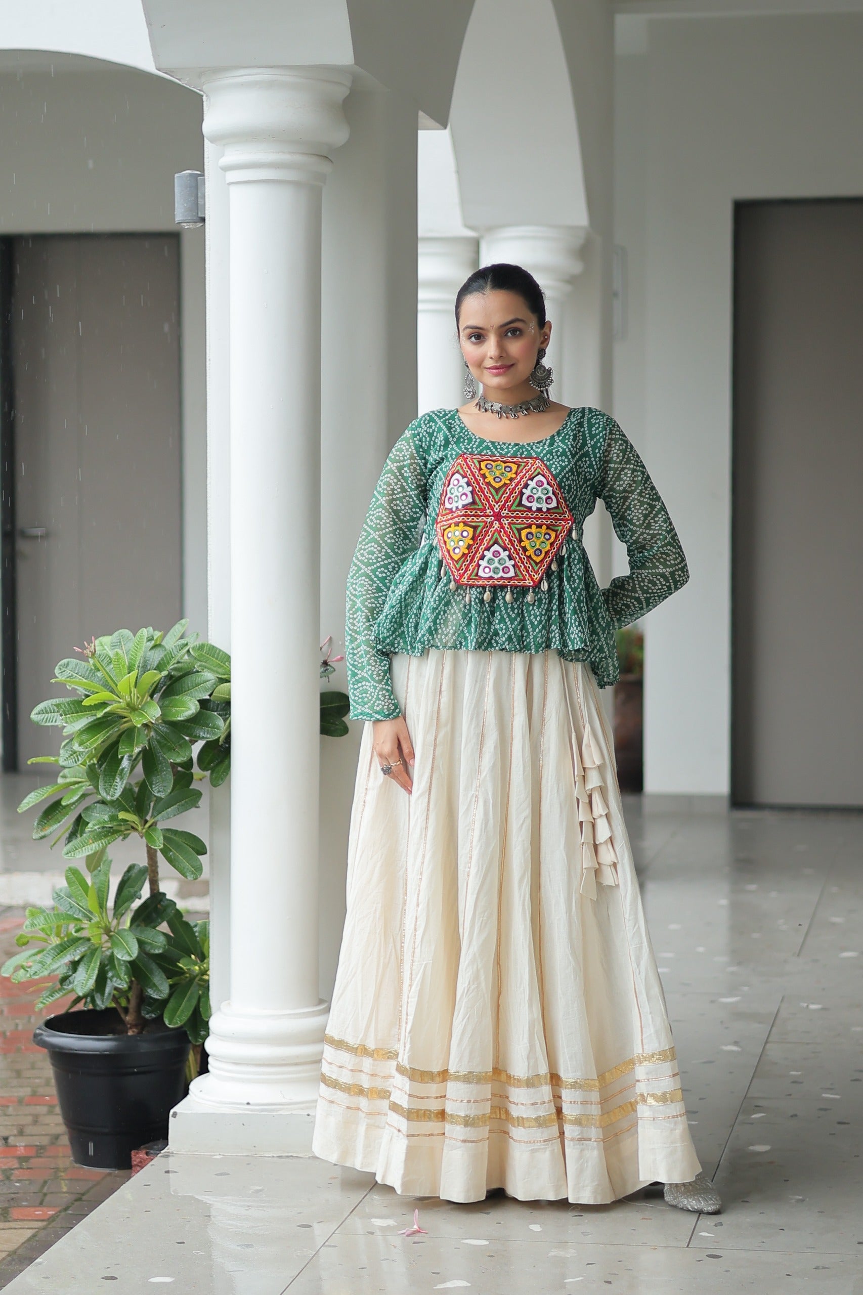 A green Bandhani print lehenga featuring intricate Kutchi Gamthi patchwork and Gota-Patti lace detailing for Navratri.