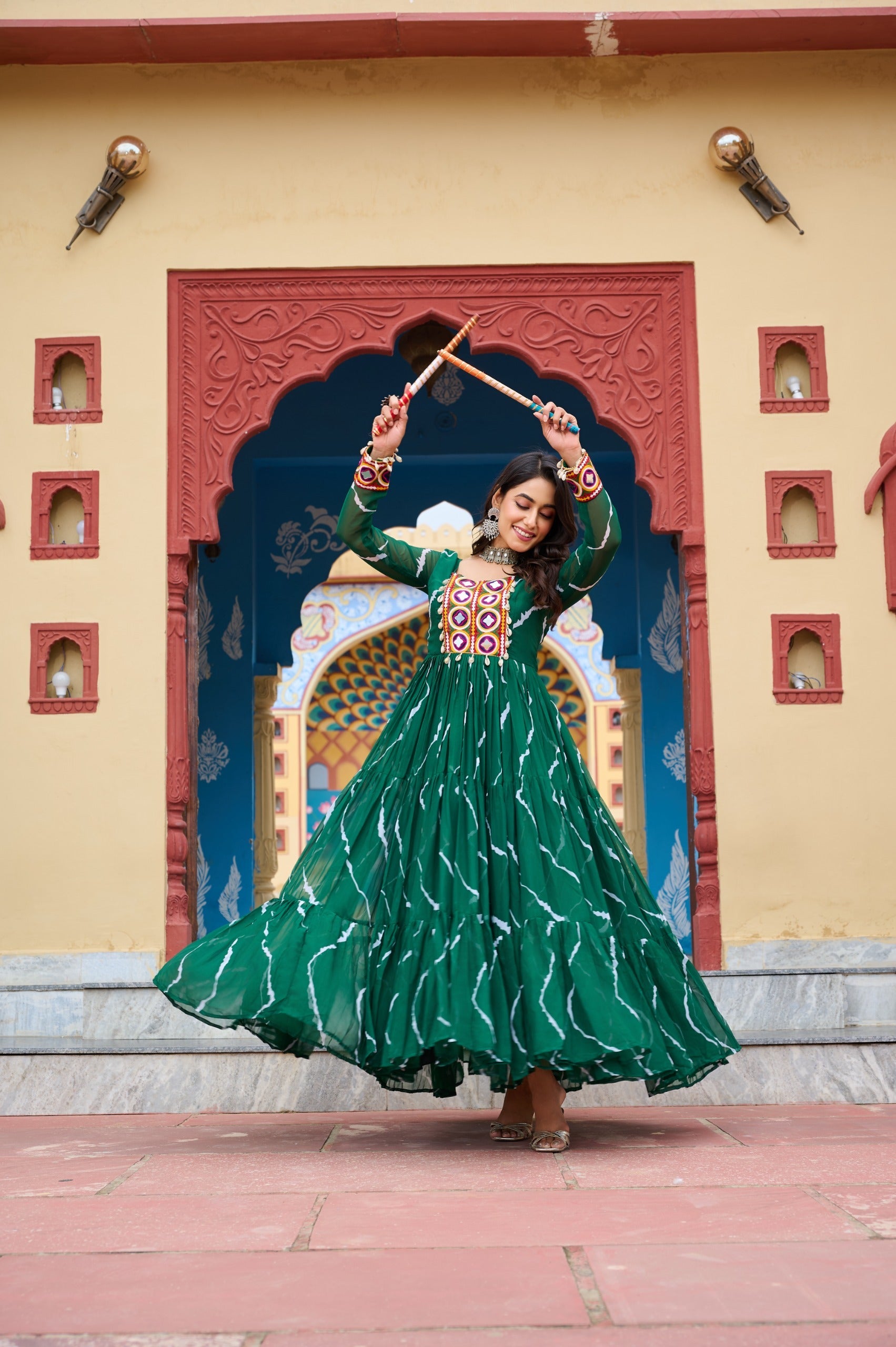 Green georgette gown with Laheriya print and intricate Kutchi patchwork for festive wear.