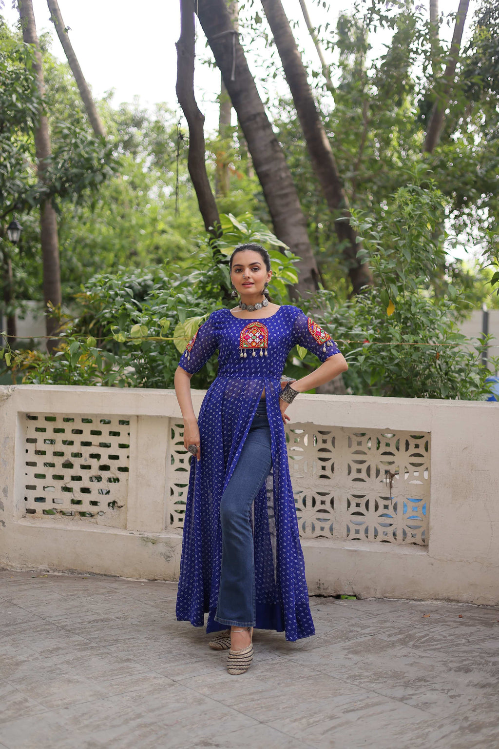 A blue Faux Georgette Bandhani print kurti featuring traditional Kutchi patch work and a 52-inch length.