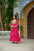 A vibrant pink georgette gown featuring traditional Bandhani print and colorful Kutchi patchwork for festive wear.