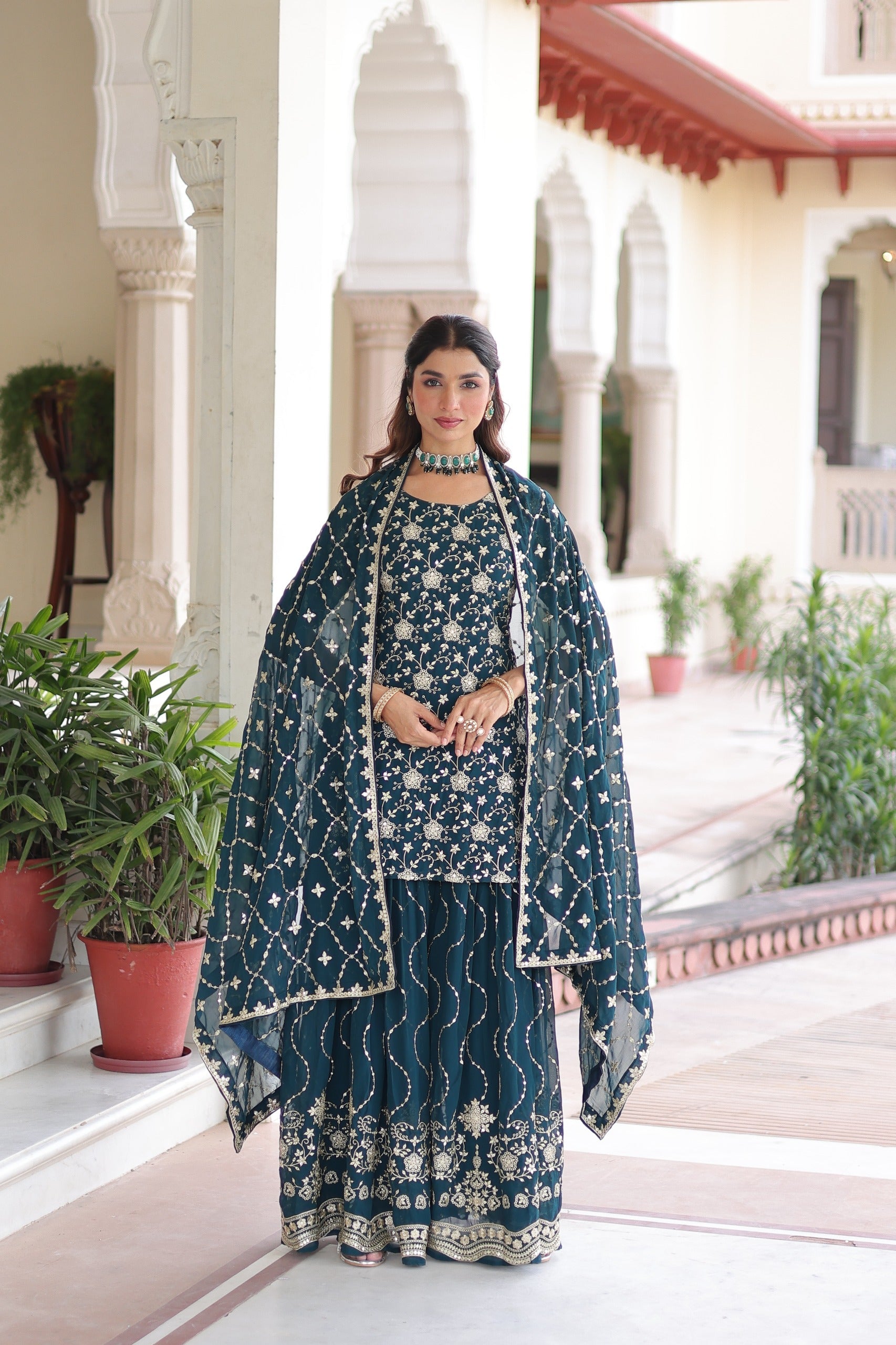 A stylish blue georgette sharara suit adorned with intricate sequins embroidery work.