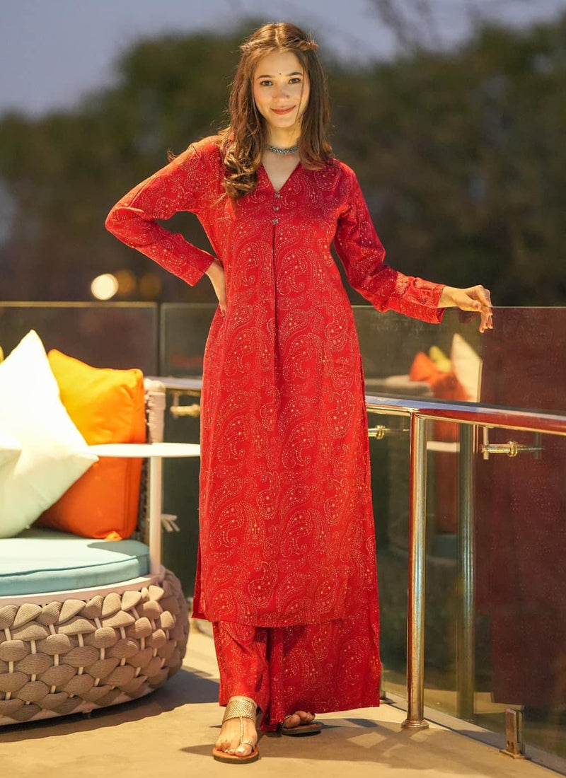 Woman wearing a vibrant red digital print designer kurti and matching pants for a festive occasion