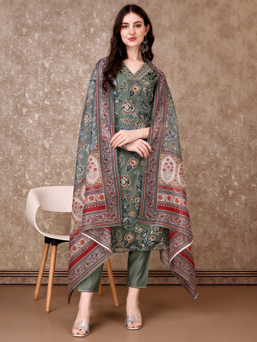 Woman wearing a green hand-embroidered Brasso kurta with matching pants and a printed organza dupatta.