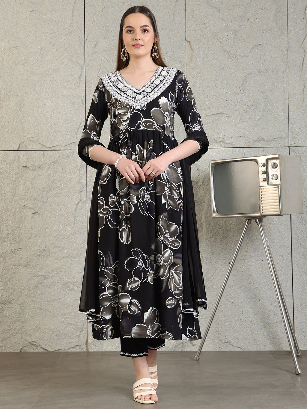 Black flared A-line kurta with floral prints and embroidery, worn with matching pants and dupatta.