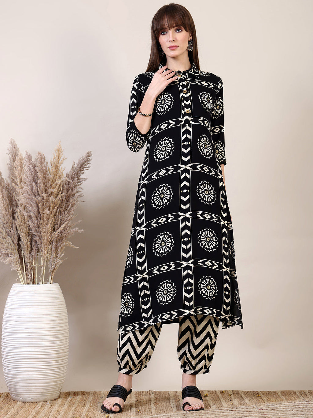 Black kurta with ethnic motif print paired with stylish Afghani pants.