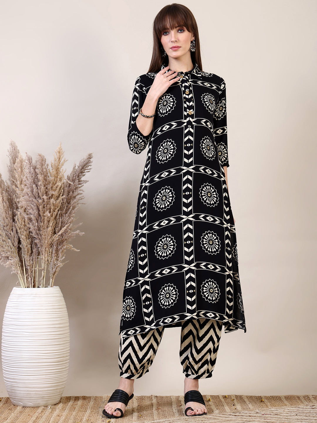 Black kurta with ethnic motif print paired with stylish Afghani pants.