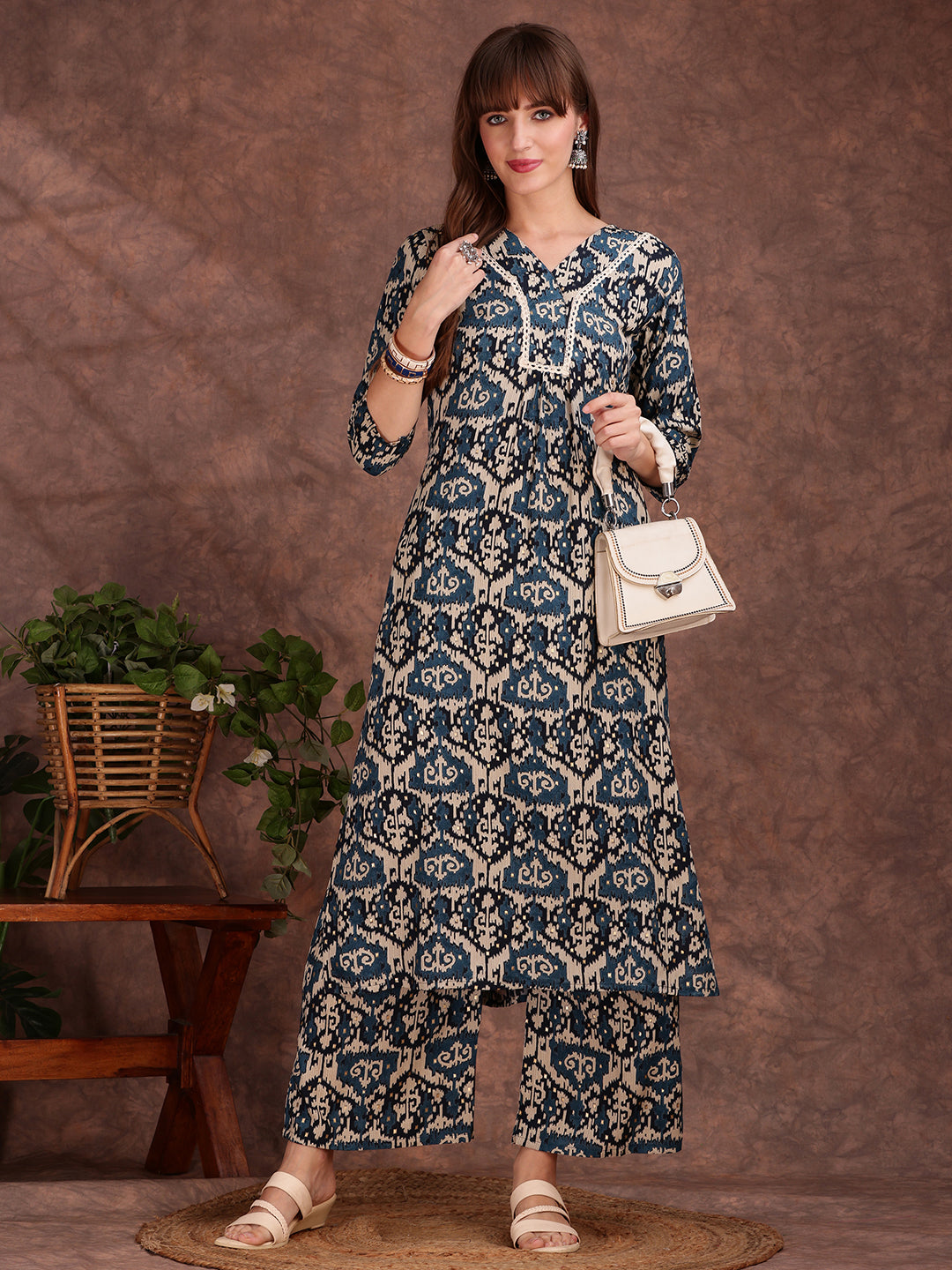 Woman wearing a teal rayon kurta with ethnic motifs and lace trim paired with matching palazzo pants