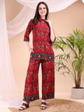 A woman wearing a vibrant red printed co-ord set consisting of a collar neck shirt and matching palazzo pants