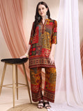 A woman wearing a vibrant red tunic and palazzo set featuring intricate floral and paisley print motifs.