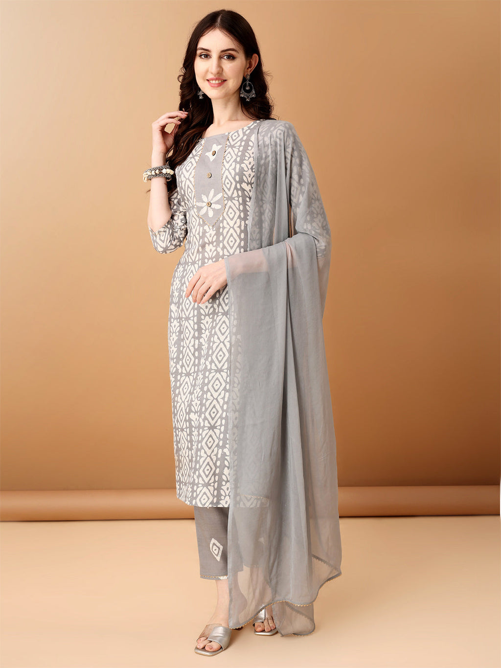 Woman wearing a grey Bandhani printed cotton kurta set with matching pants and dupatta.