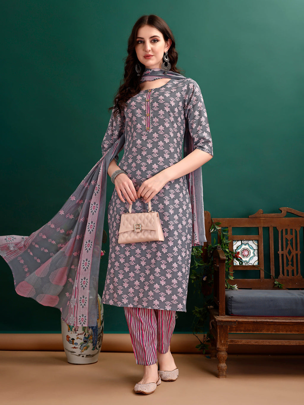 A woman wearing a multicolor ethnic motif printed kurta set with matching pants and dupatta.