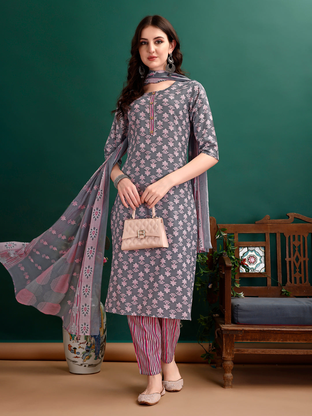 A woman wearing a multicolor ethnic motif printed kurta set with matching pants and dupatta.