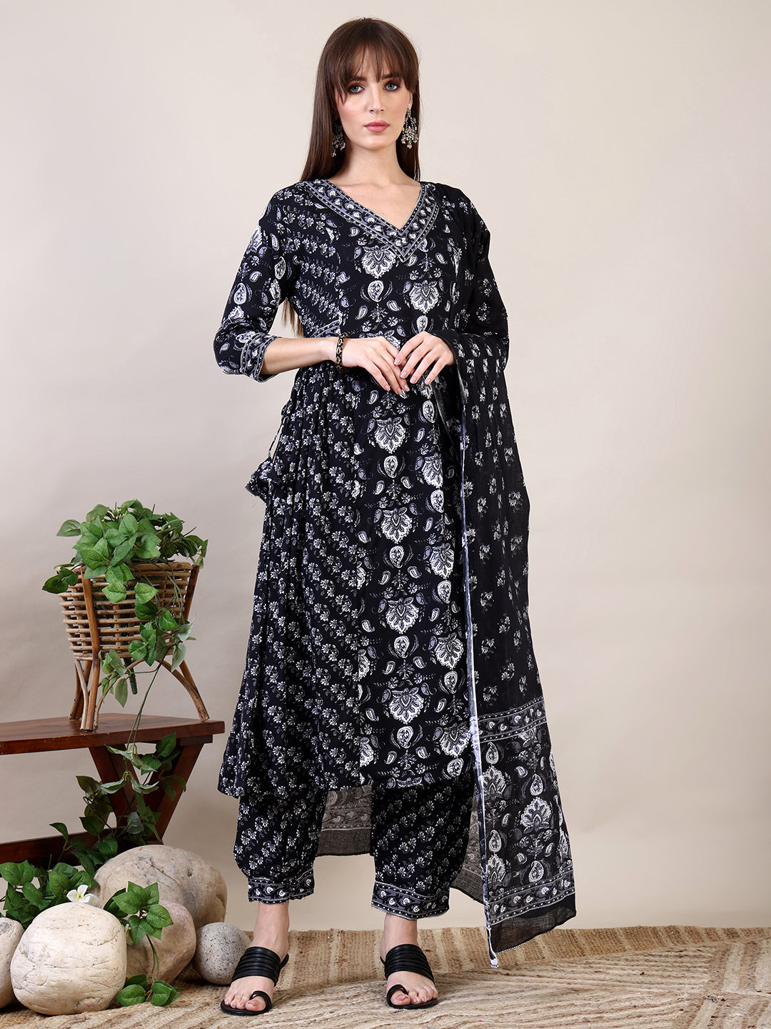 Woman wearing a black printed flared kurta set with matching Afghani pants and dupatta
