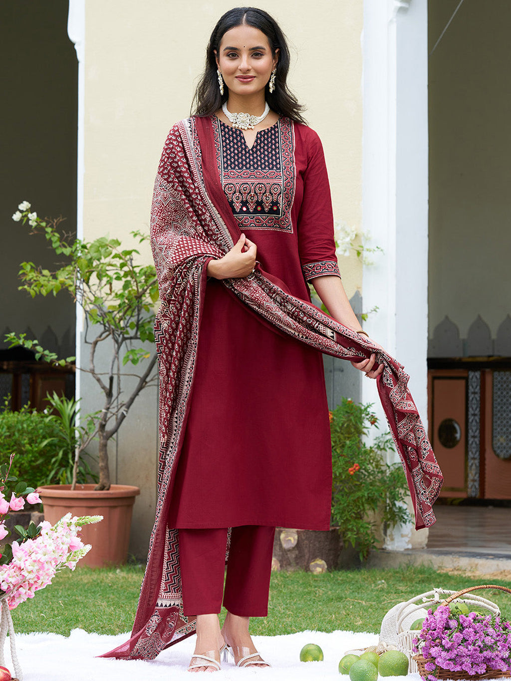 A maroon embroidered cotton kurta paired with matching pants and a printed dupatta, featuring a sweetheart neckline.