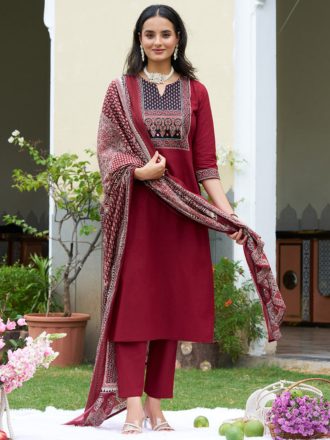 A maroon embroidered cotton kurta paired with matching pants and a printed dupatta, featuring a sweetheart neckline.