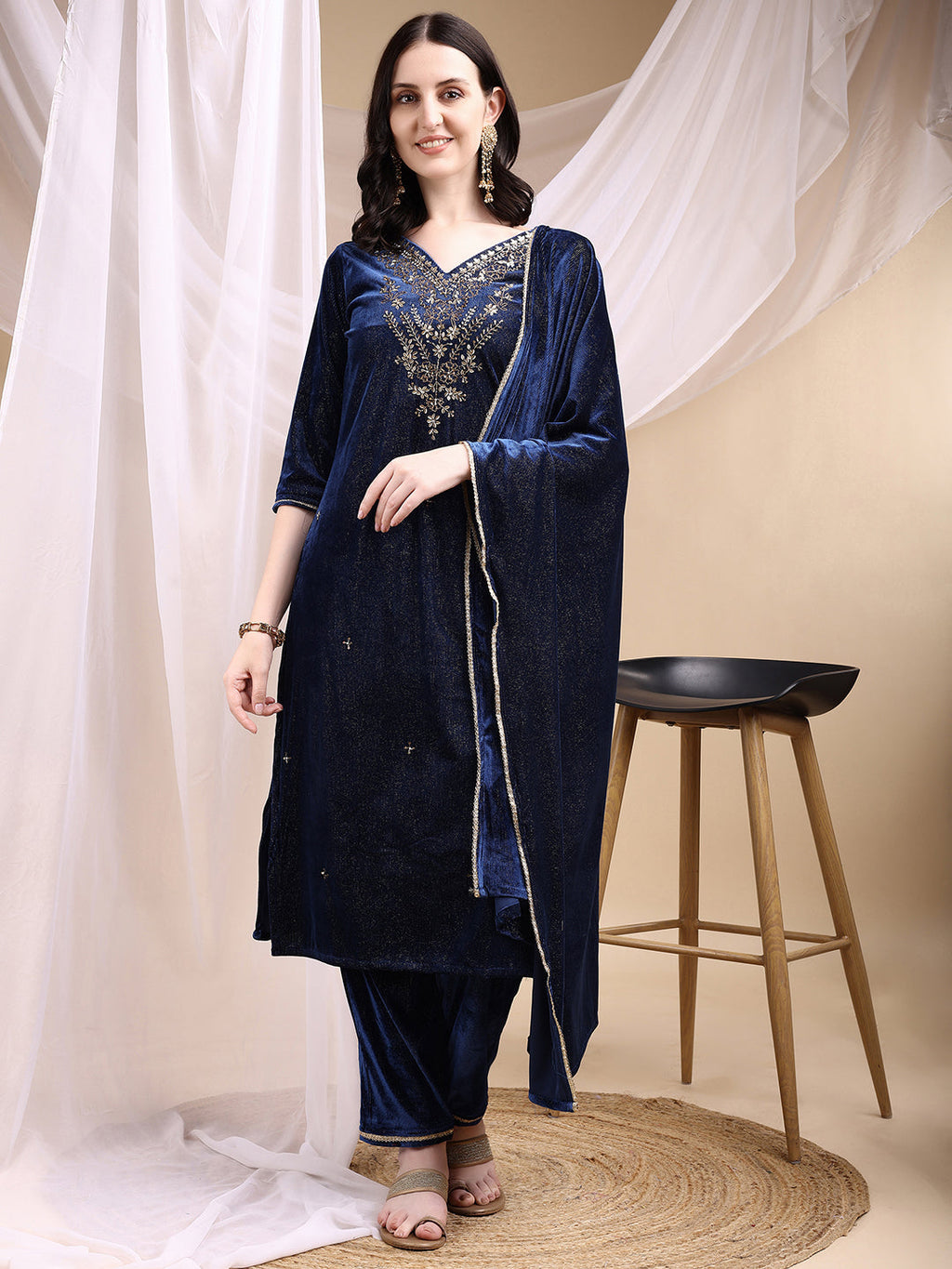 Navy blue velvet kurta with hand embroidery, paired with matching pants and a dupatta.