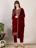 Woman wearing a maroon embroidered velvet kurta set with matching pant and dupatta