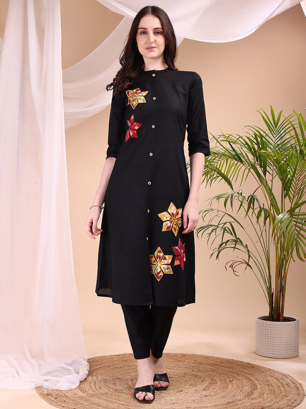 Woman wearing a black placement floral kurta with matching pants and 3/4th sleeves