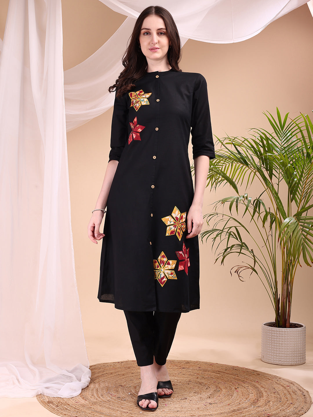 Woman wearing a black placement floral kurta with matching pants and 3/4th sleeves