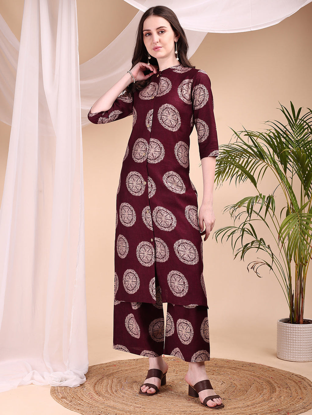 Woman wearing a wine-colored ethnic motif printed kurta with matching palazzo pants in silk-blend fabric