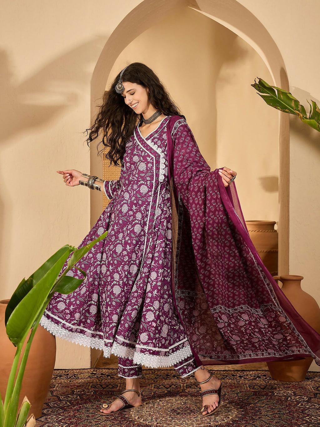 Woman wearing a purple printed pure cotton kurta set with V-neck and 3/4 sleeves