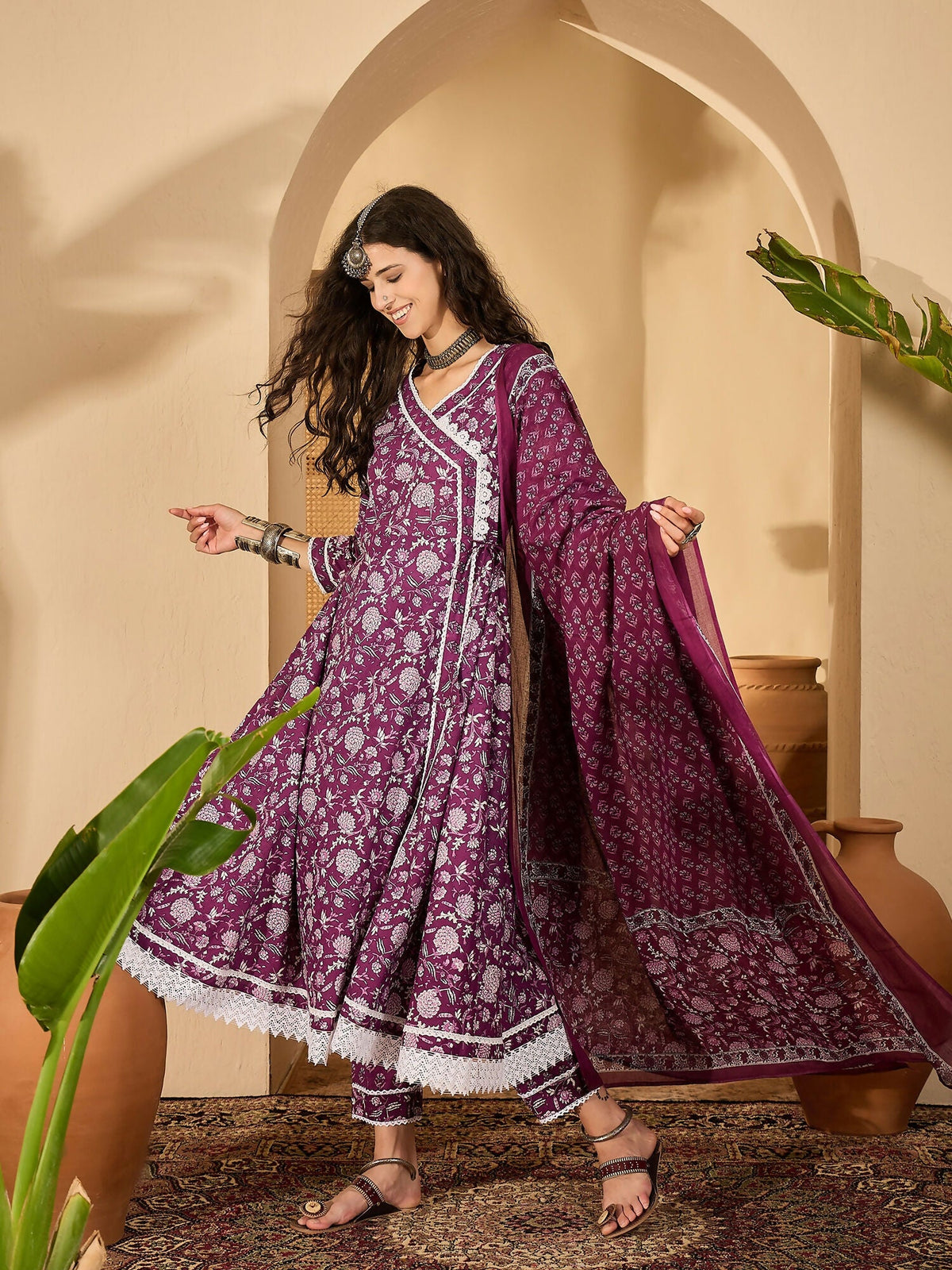 Woman wearing a purple printed pure cotton kurta set with V-neck and 3/4 sleeves