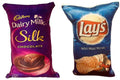Set of two reversible kids' cushions with Dairy Milk Silk and Blue Lays snack packaging designs.