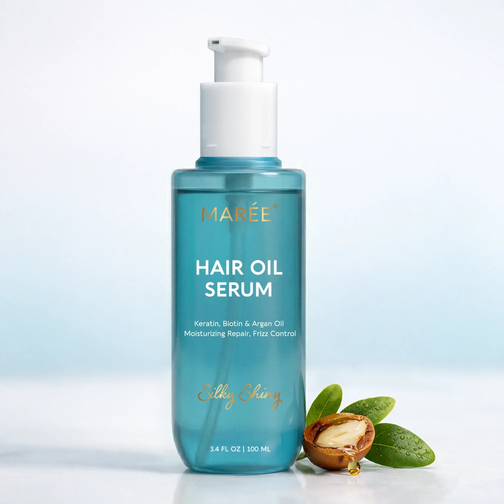 A 100ml bottle of Maree Keratin and Argan Oil Hair Serum next to a fresh argan nut and green leaves.