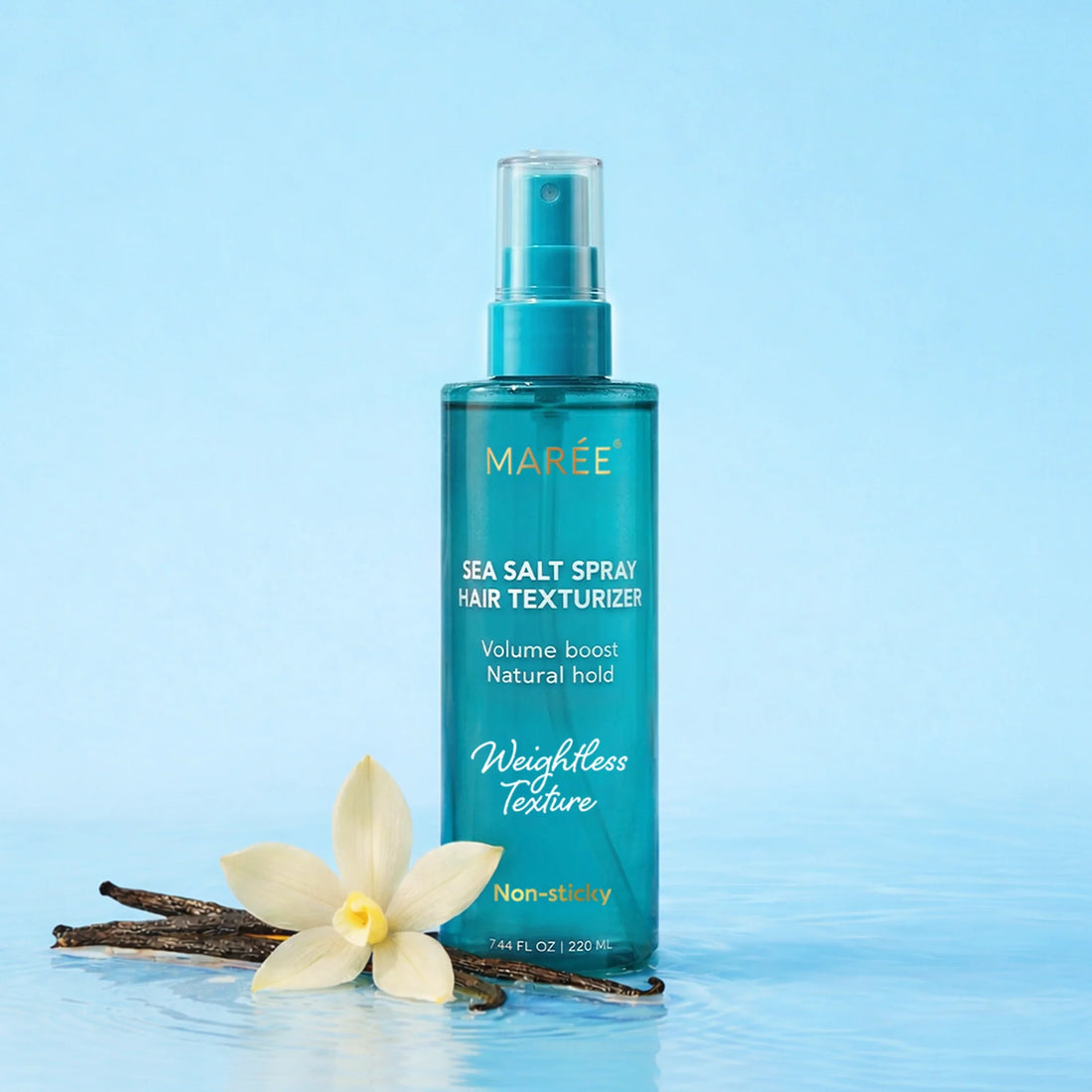 Bottle of Maree Keratin and Sea Salt Hair Texturizer spray next to vanilla bean and flower on blue background