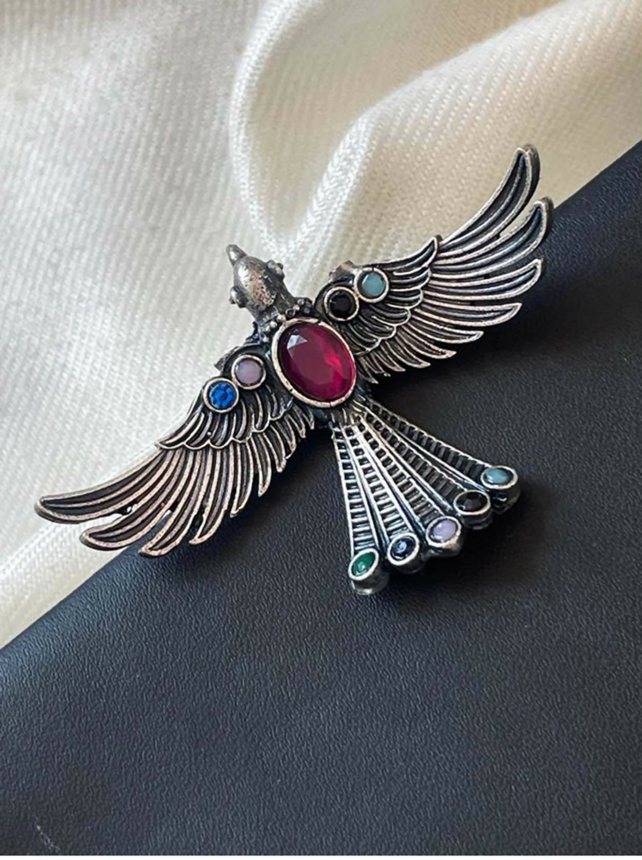 Pink oxidized brass eagle shape statement ring viewed from the top