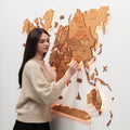 3D LED Wooden World Map 3.0 in Oak mounted on a wall with vibrant backlighting