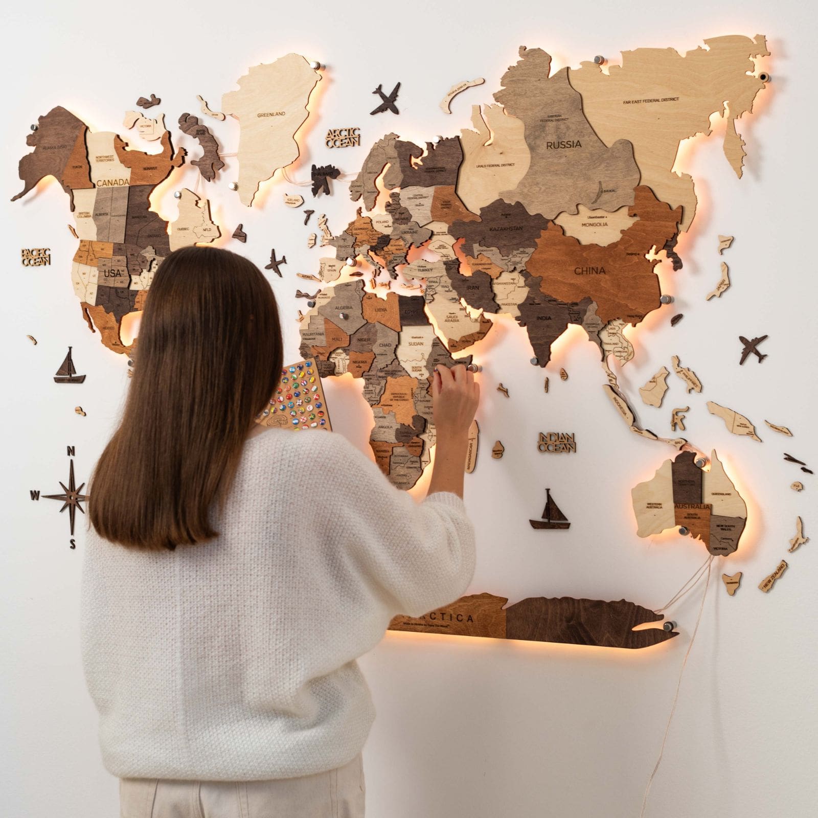 3D LED wooden world map with multicolor backlight installed on a minimalist living room wall