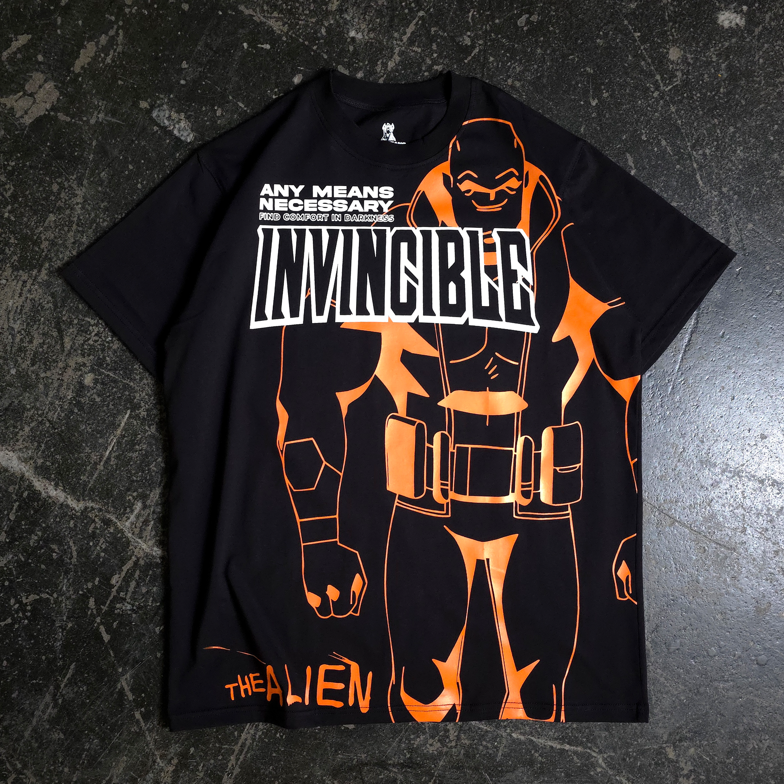 A man wearing a black graphic t-shirt with orange Invincible line art standing in a hobby shop